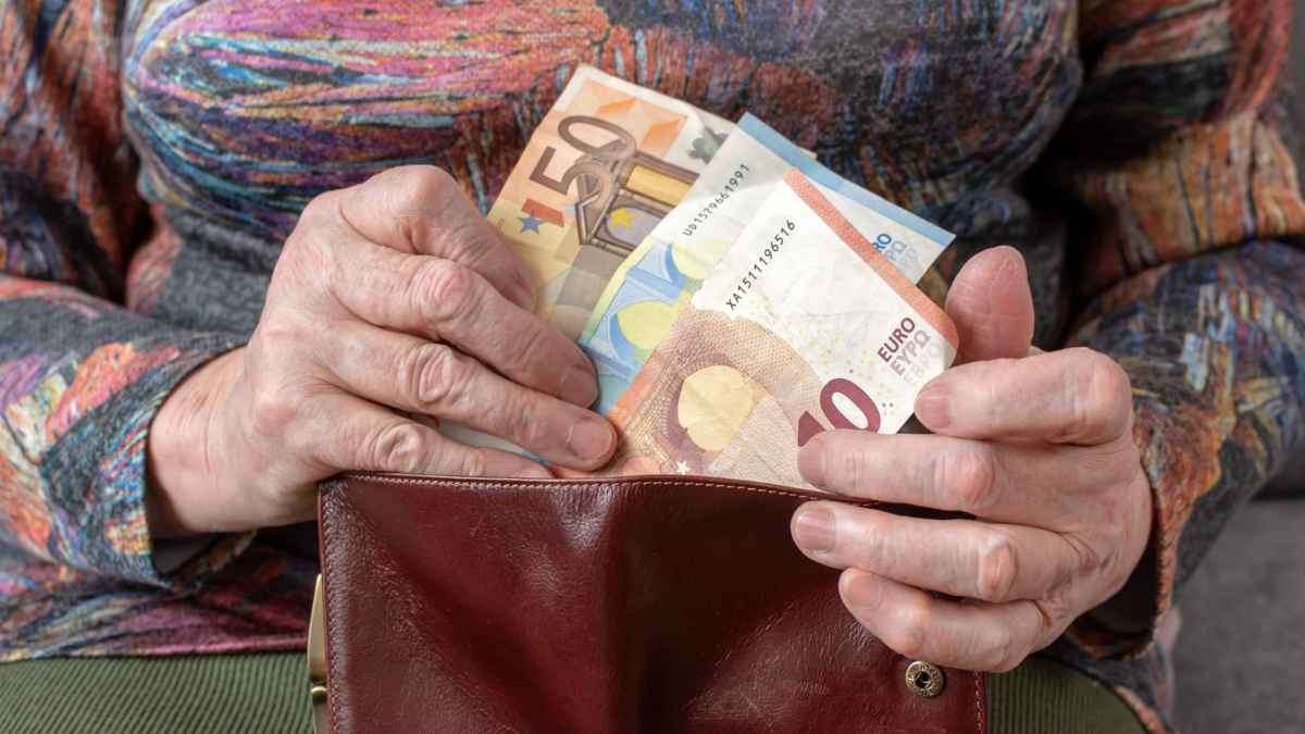 Persona mayor contando billetes de euro tras la subida de las pensiones 2026 por el IPC
