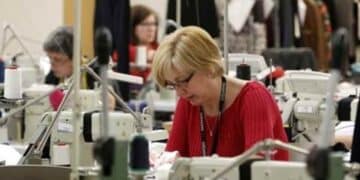 Trabajadoras del sector textil en taller de confección con subida salarial hasta 2026.