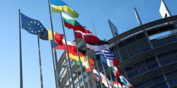 Banderas de la Unión Europea frente al Parlamento Europeo, sobre el nuevo reglamento de transferencias instantáneas sin comisiones.
