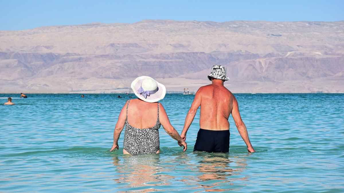 Jubilados disfrutando de un viaje del Imserso en la playa gracias a la herramienta online de reservas.