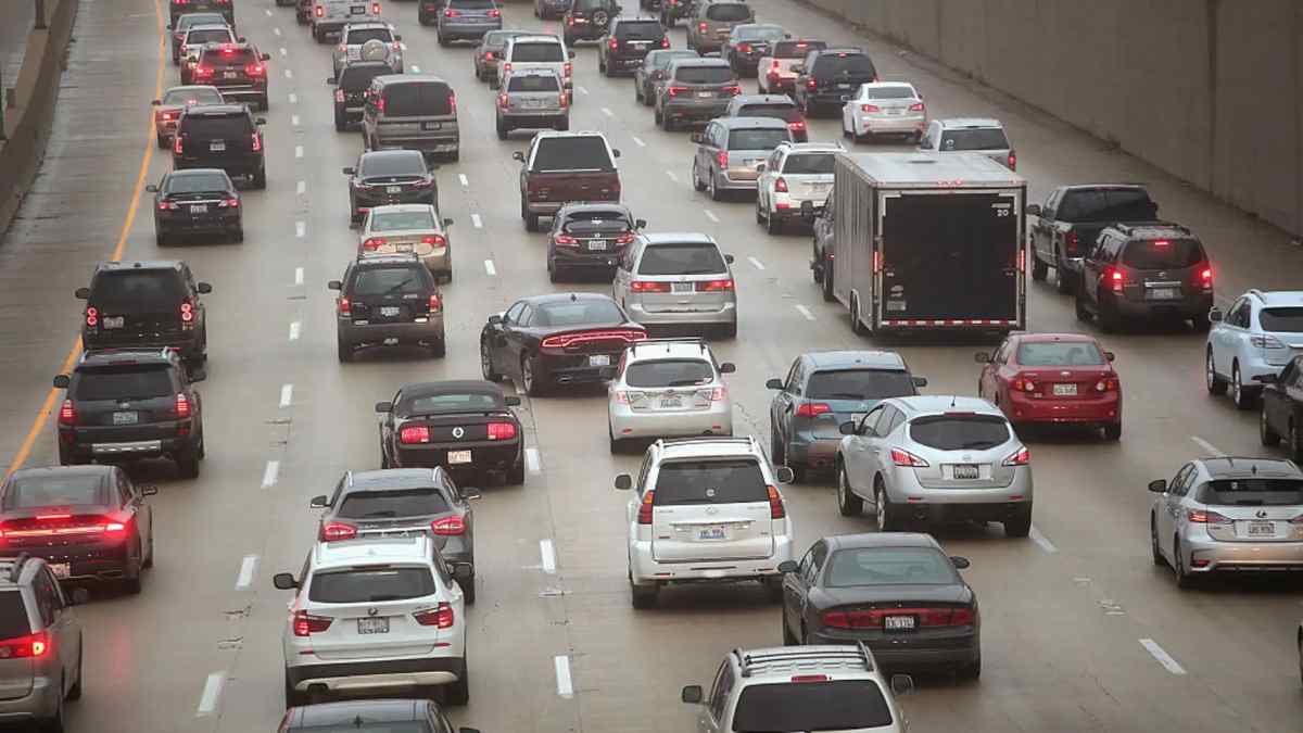 Tráfico denso con vehículos cambiando de carril en una autovía.