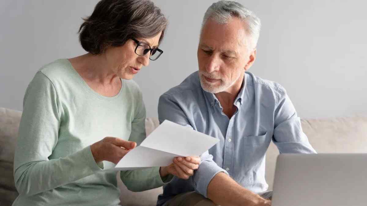 Pareja de jubilados revisando documentos sobre el complemento de la Seguridad Social.