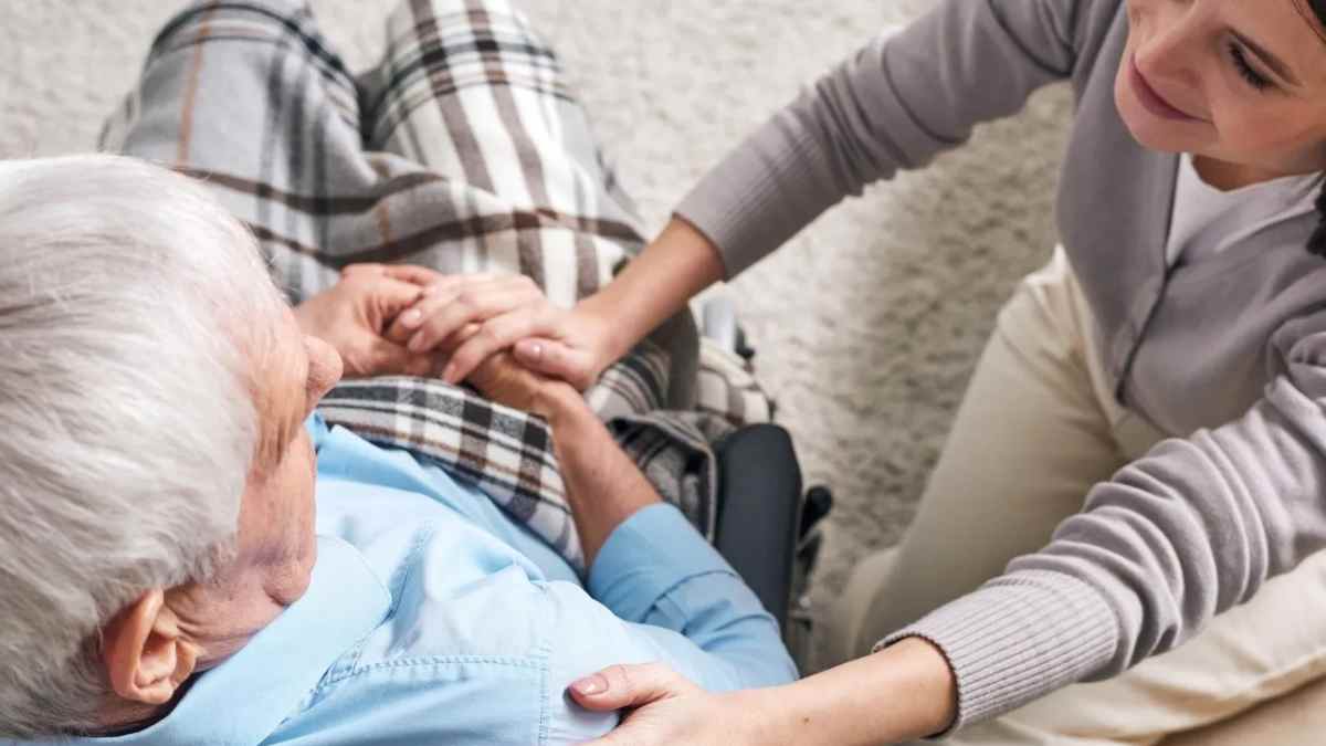 Cuidadora atendiendo a persona mayor en programa de apoyo del Ayuntamiento de Madrid.