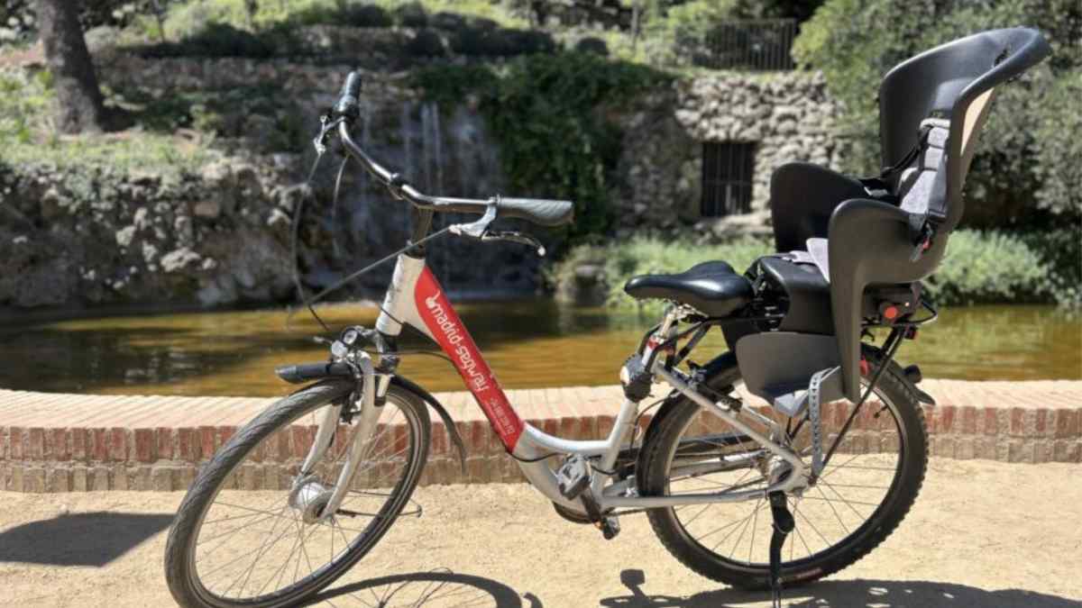 Bicicleta del servicio Bicibebas de Madrid con sillita infantil en el parque de Valdebebas.