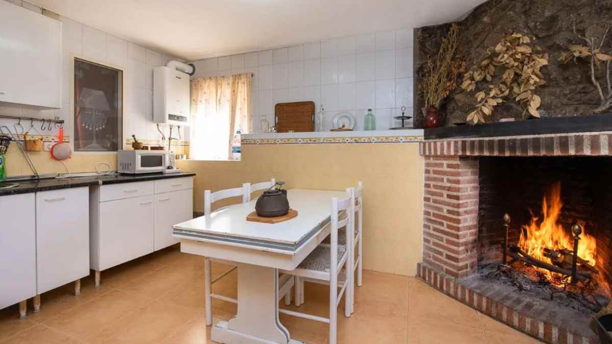 Cocina rústica con chimenea en casa en venta en Madrid desde 69.900 euros.