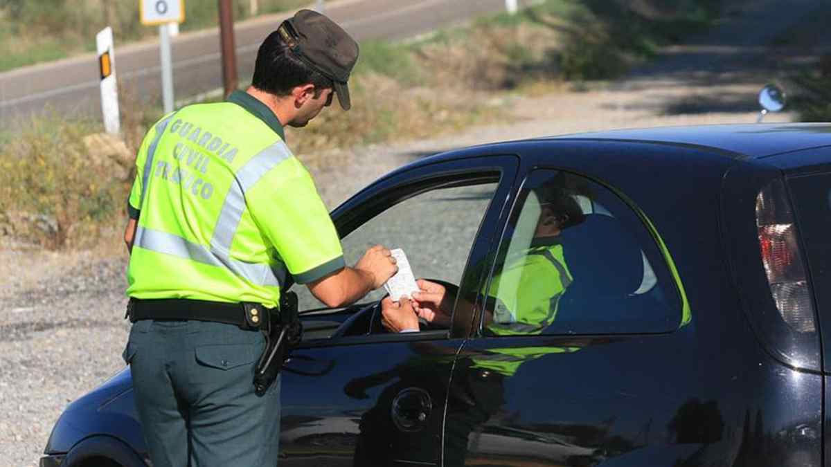 Agente de tráfico entregando una multa a un conductor durante un control de la DGT.