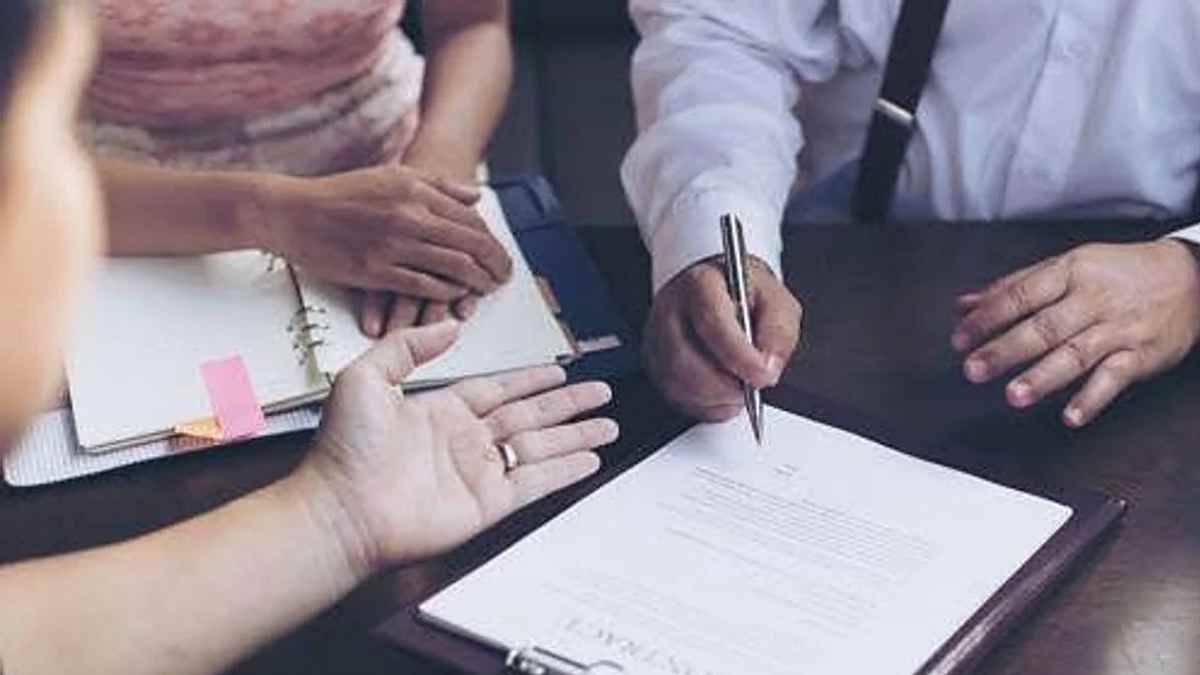 Personas firmando documentación sobre una herencia y la gestión de cuentas conjuntas.