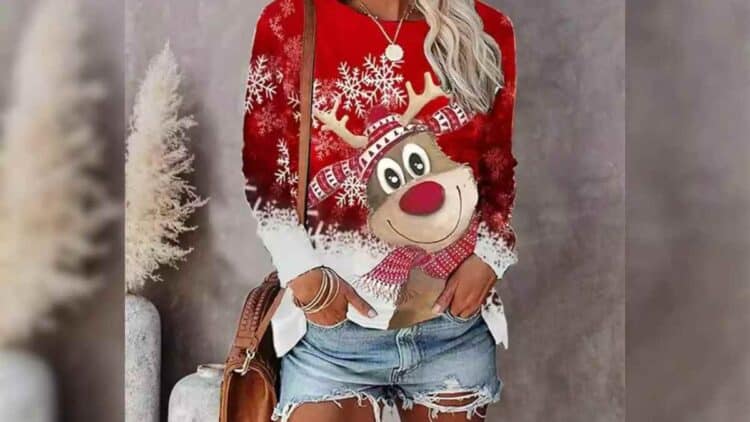 Mujer con jersey navideño rojo con reno y copos de nieve disponible en Amazon por menos de 20 euros.