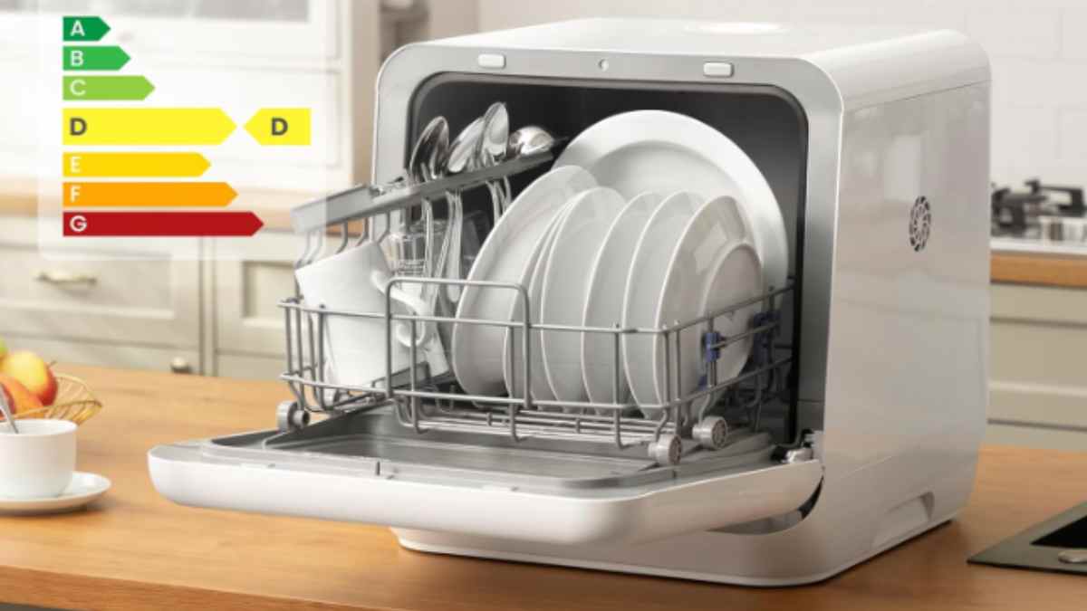 Lavavajillas de encimera compacto con vajilla colocada en la bandeja y etiqueta energética.