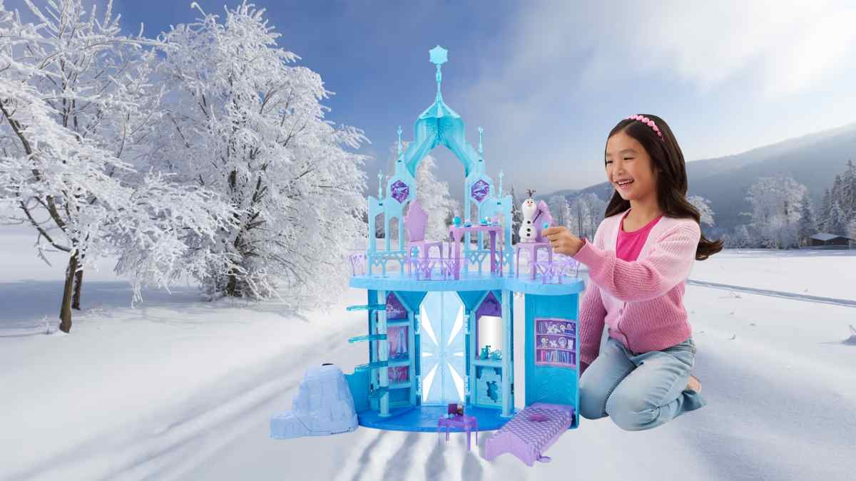 Niña jugando con el Palacio de hielo de Elsa de Mattel junto a la figura de Olaf en un paisaje nevado.