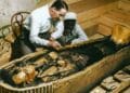 Arqueólogo examina el sarcófago de Tutankamón en su tumba original de Egipto.