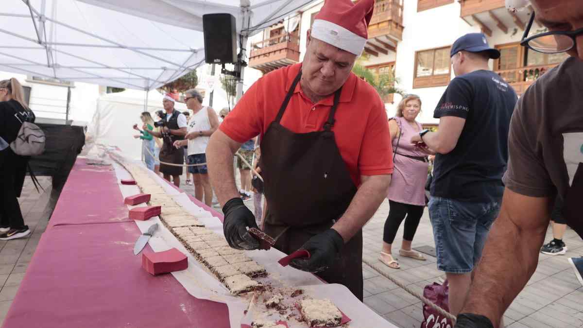 Maestro repostero corta el turrón gigante repartido gratis en el centro de Madrid.