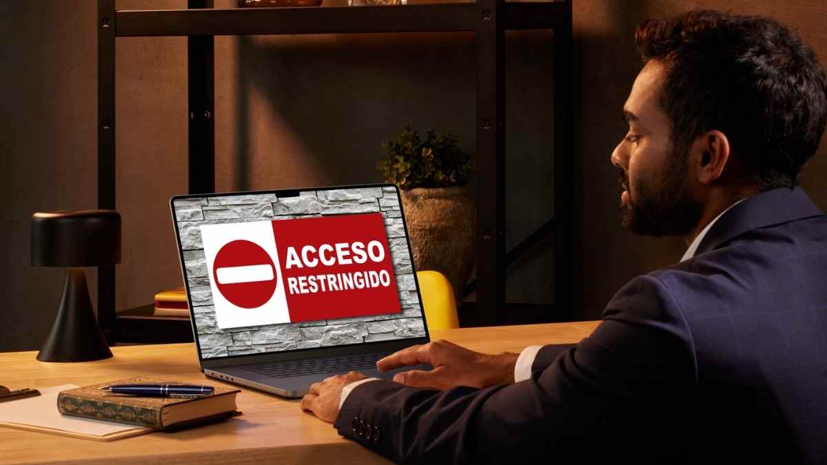 Trabajador frente a ordenador con acceso restringido que simboliza los derechos digitales en el trabajo según el artículo 20 bis.