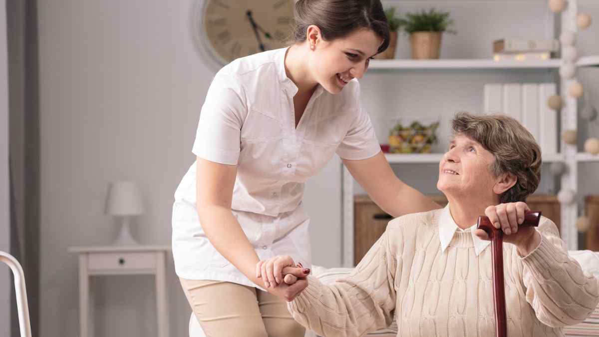 Cuidadora ayudando a una persona mayor en su domicilio.