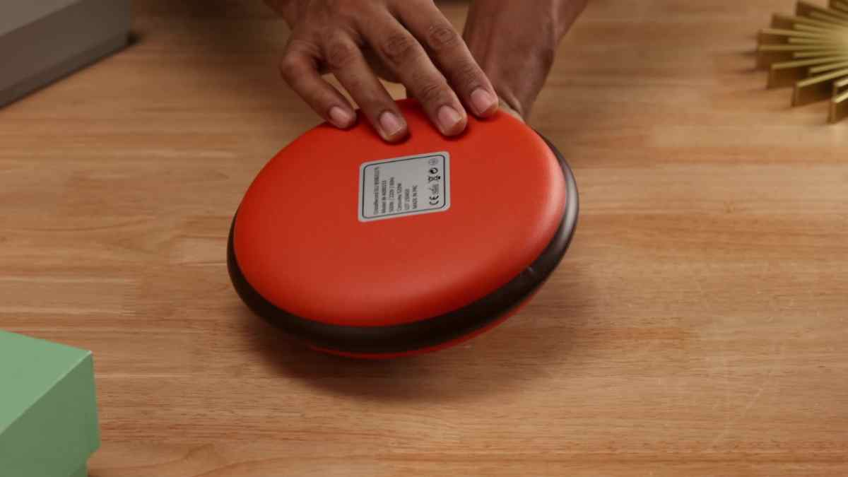 Calientacamas eléctrico Wonderlamp de color rojo colocado sobre una mesa de madera.