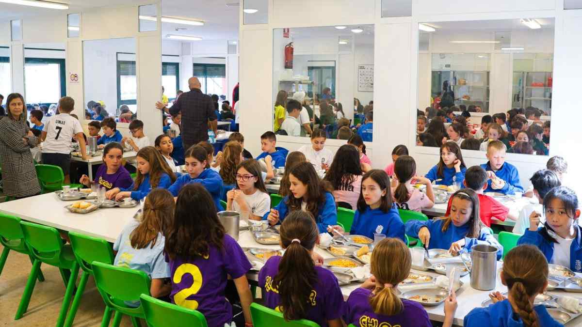 Niños y niñas comiendo en el comedor escolar de un colegio en Madrid.