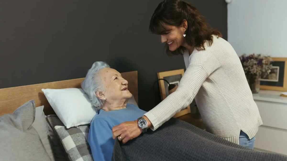 Mujer cuidando a una persona mayor en su hogar, imagen relacionada con el subsidio para mayores de 52 años.