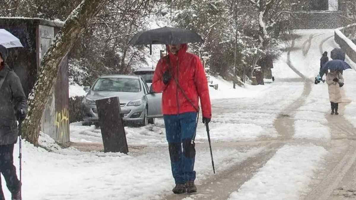 Personas caminan por una calle nevada en Madrid durante un episodio de frío invernal