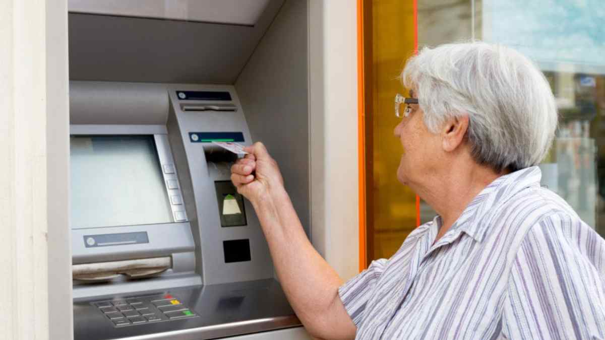 Pensionista retirando su pensión en un cajero automático en diciembre.