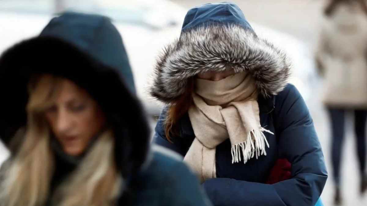 Personas abrigadas en Madrid durante una mañana de frío húmedo con sensación térmica cercana a 0 grados.