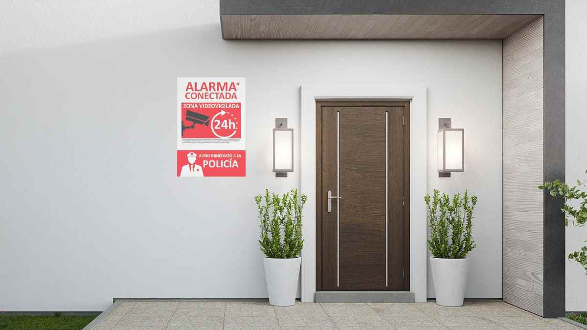 Entrada de vivienda con cartel de alarma conectada que podría acarrear multas según la Ley de Seguridad Privada.