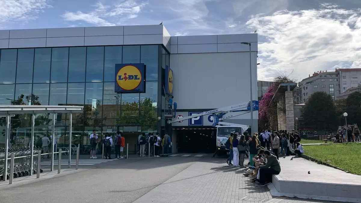 Muchedumbre de personas haciendo cola en un supermercado Lidl para comprar un producto de belleza.