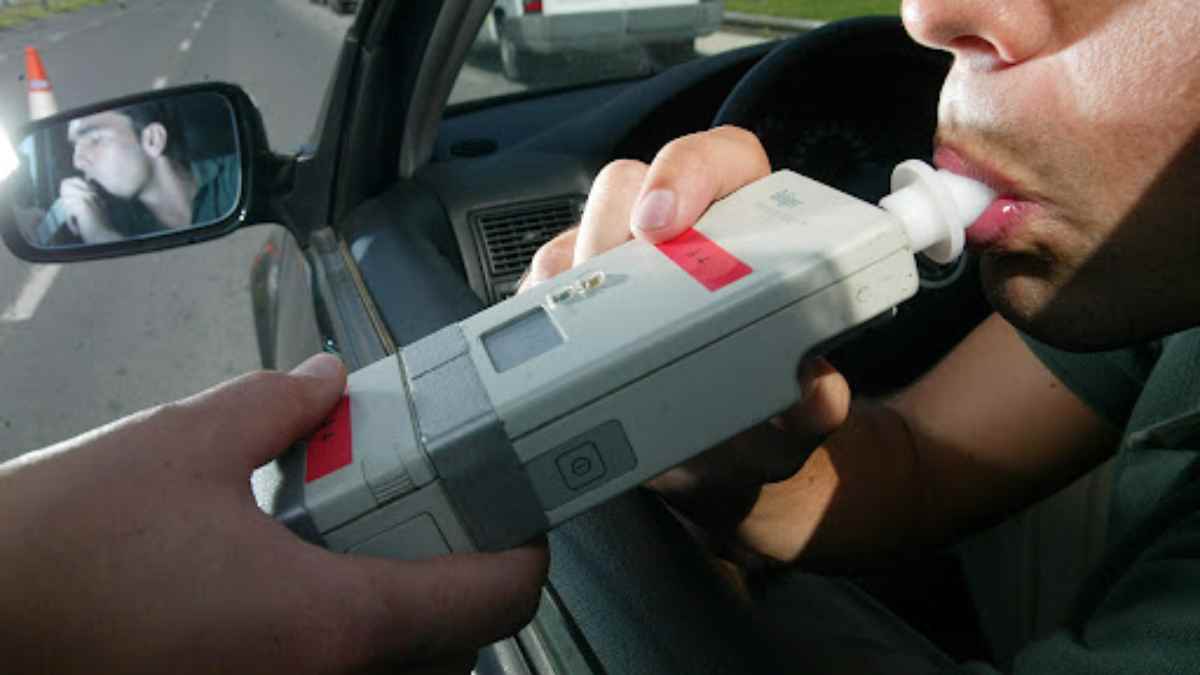 Conductor realizando prueba de alcoholemia con etilómetro de la DGT.