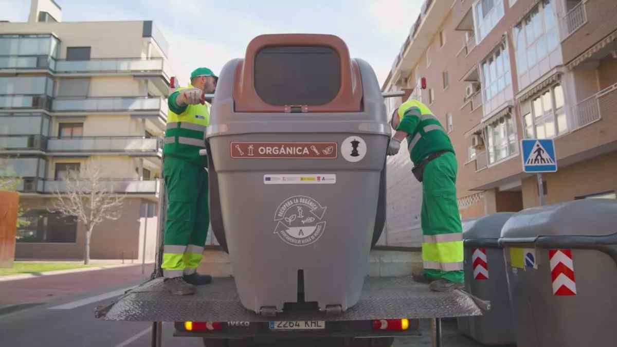 Operarios recogen un contenedor de residuos en Madrid durante el servicio municipal de limpieza