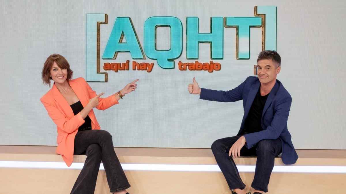 Presentadores de ‘Aquí hay trabajo’ posan en el plató junto al logo del programa.
