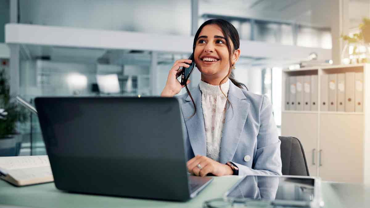 Empleada realizando una llamada telefónica en la oficina con el teléfono corporativo.