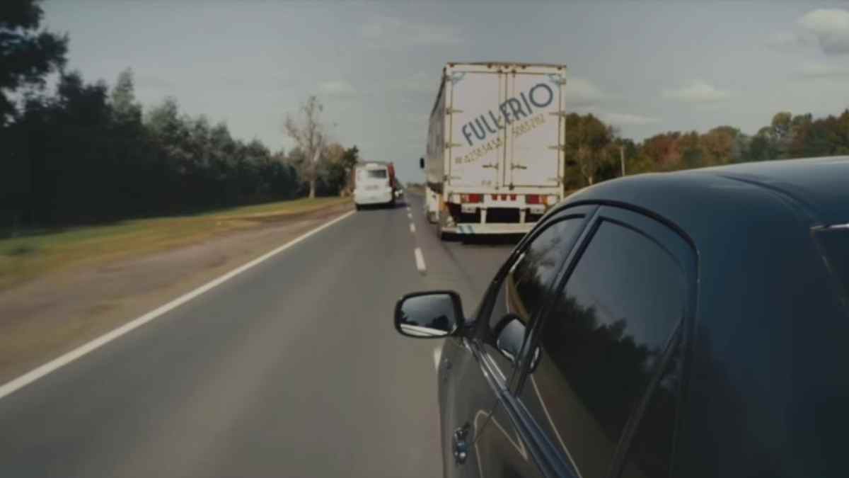 Turismo circulando junto a un camión en carretera donde la DGT puede prohibir adelantamientos