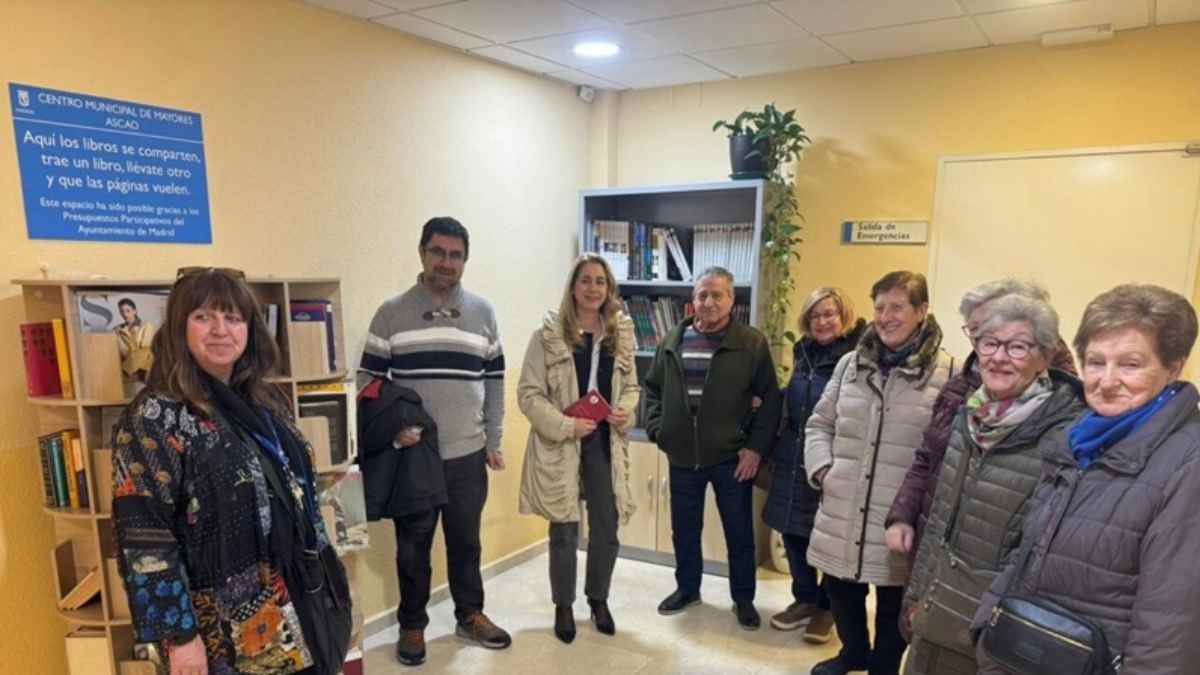 Personas mayores en un centro de mayores de Madrid junto a un punto de intercambio de libros