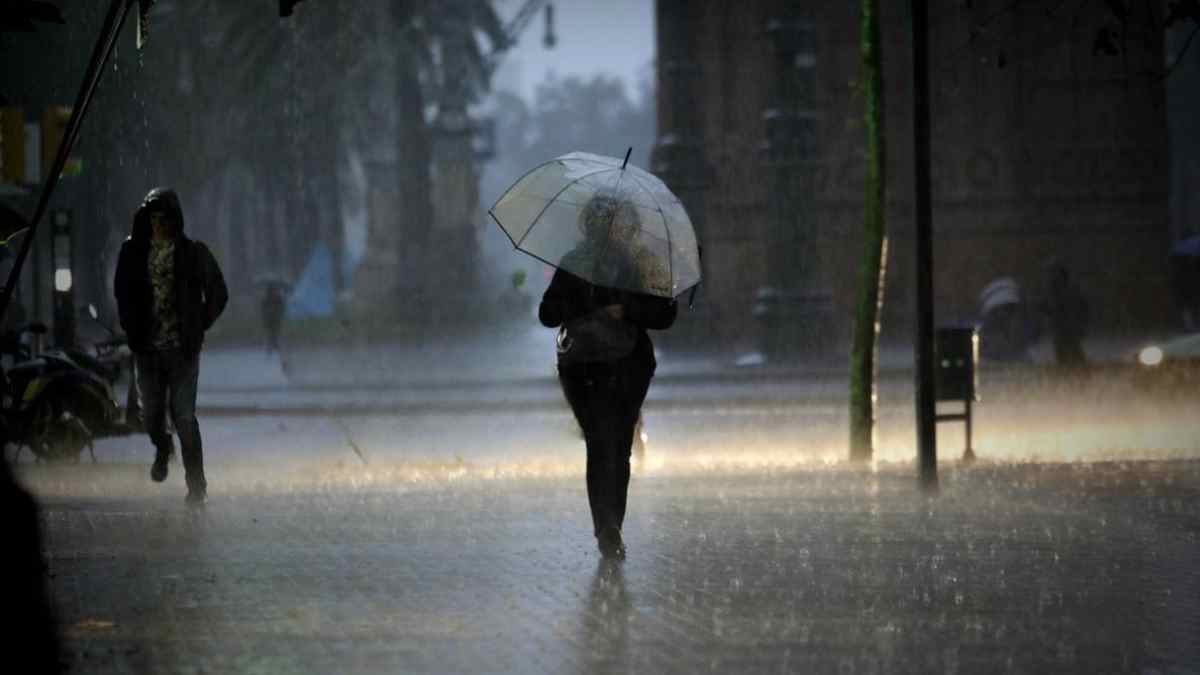 Personas caminando bajo lluvias intensas en Madrid con paraguas durante un episodio de mal tiempo