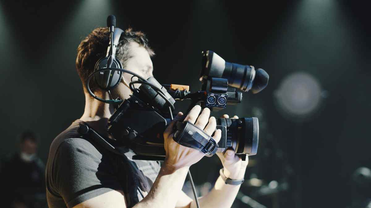 Profesional audiovisual grabando con cámara, uno de los beneficiarios de la ayuda del SEPE de hasta 600 euros