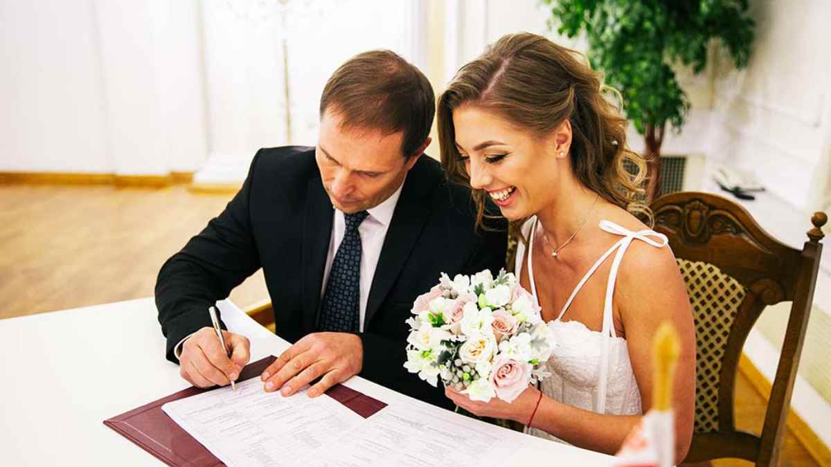 Pareja firmando el acta durante una boda civil en Madrid tras reservar fecha online en su distrito