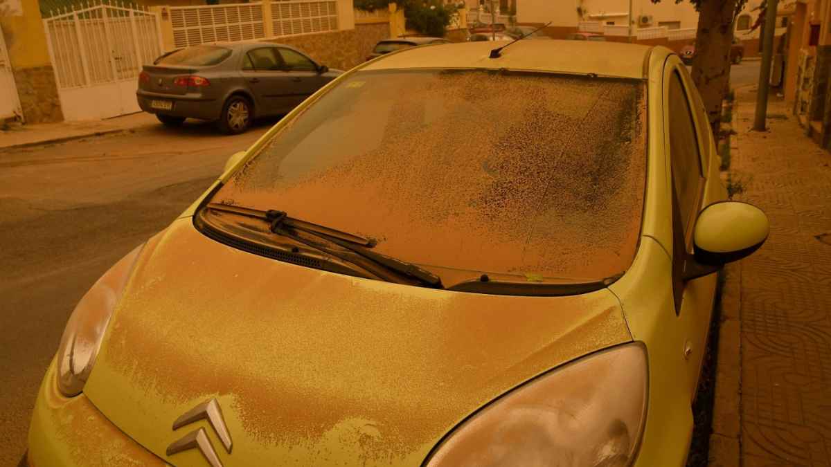 Coche cubierto de polvo sahariano por la calima en Madrid