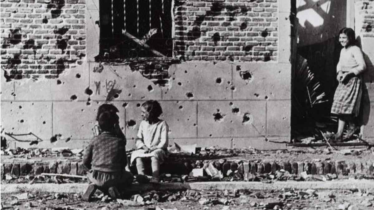 Niños frente a la casa bombardeada de Peironcely 10 fotografiada por Robert Capa en 1936