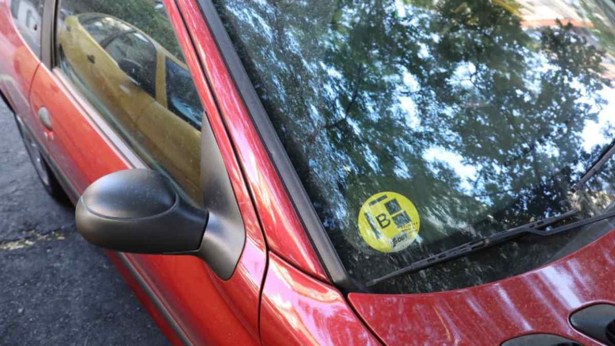 Coche con etiqueta B en el parabrisas afectado por nuevas restricciones de las ZBE en 2026