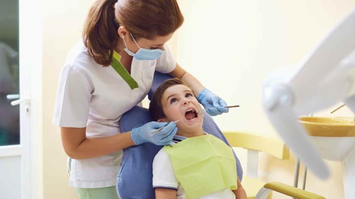 Odontóloga realizando revisión dental a un niño en clínica dentro del programa gratuito municipal en Alcorcón