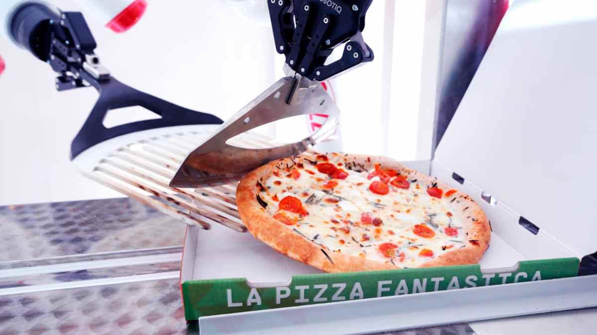 Robot preparando una pizza en un local automatizado abierto 24 horas en Chamberí