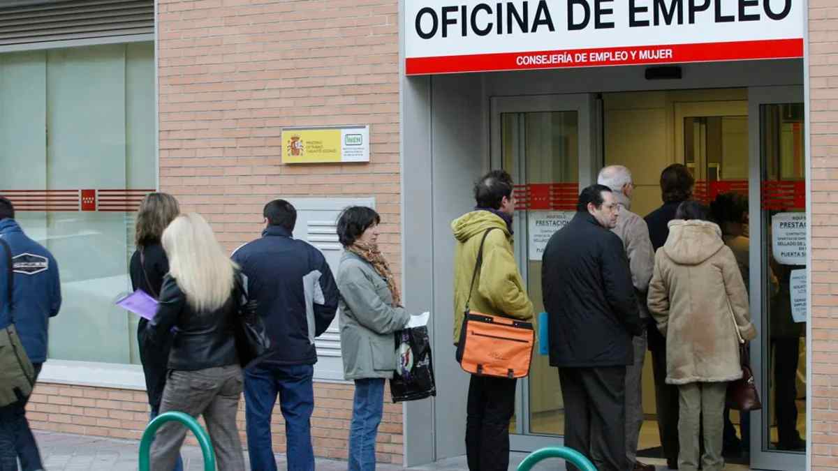 Personas esperando en la entrada de una oficina de empleo del SEPE en España
