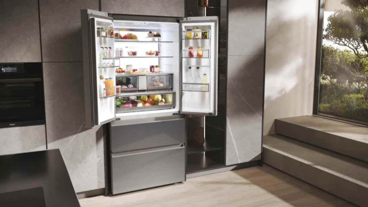 Frigorífico integrado con la puerta abierta en una cocina moderna, correctamente instalado para mejorar la ventilación