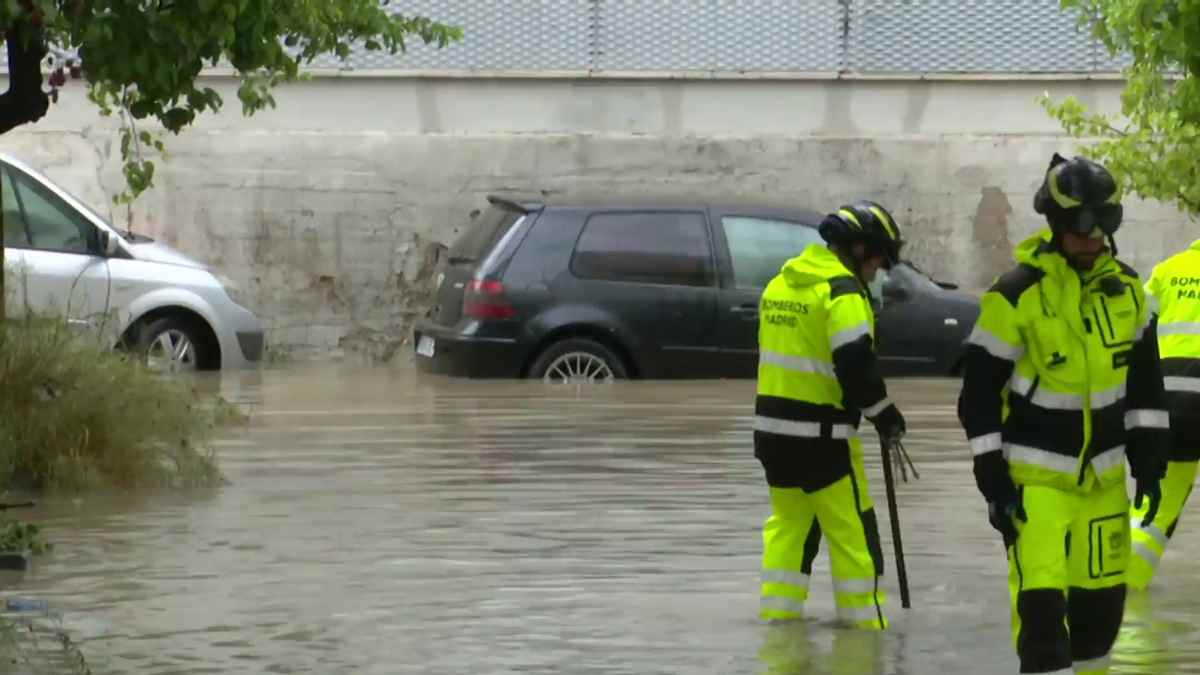 Bomberos trabajan en una calle inundada tras las lluvias provocadas por una DANA en España