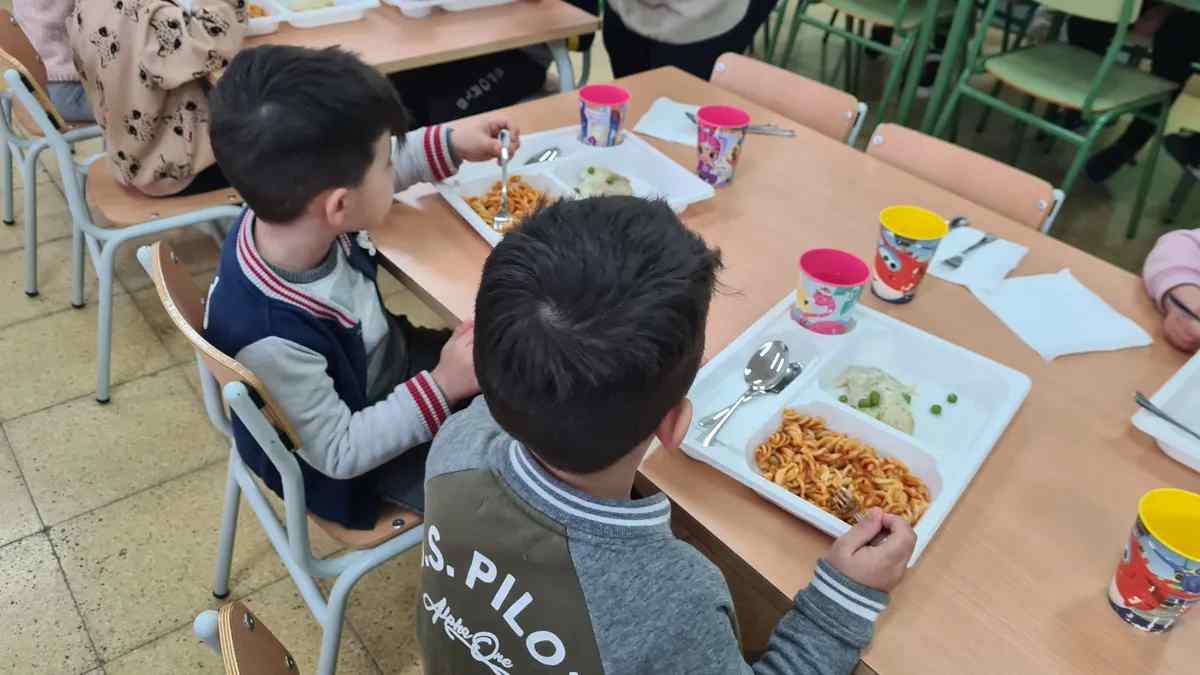 Niños comiendo en el comedor de un colegio durante el servicio de alimentación escolar
