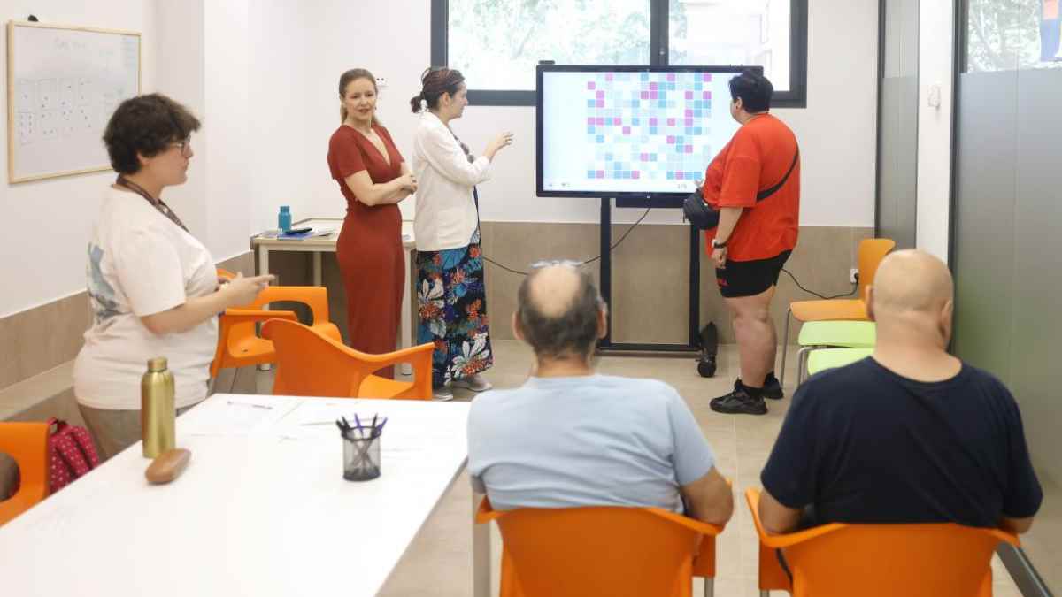 Centro social en Madrid con profesionales atendiendo a personas con enfermedad mental grave durante una actividad grupal