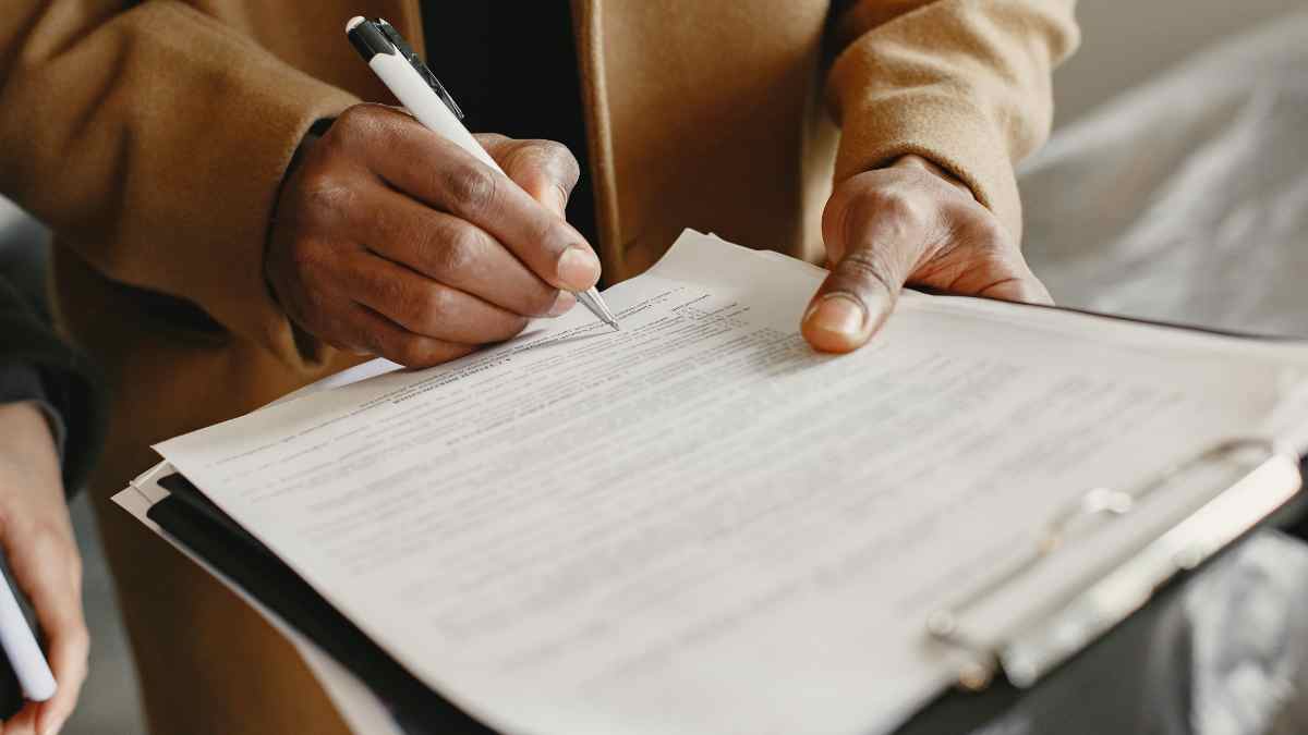 Persona firmando documentos de hipoteca para una cancelación anticipada del préstamo