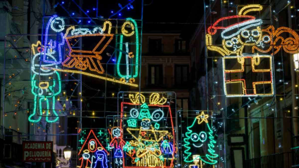 Luces de Navidad en una calle de Madrid con diseños infantiles similares a dibujos escolares