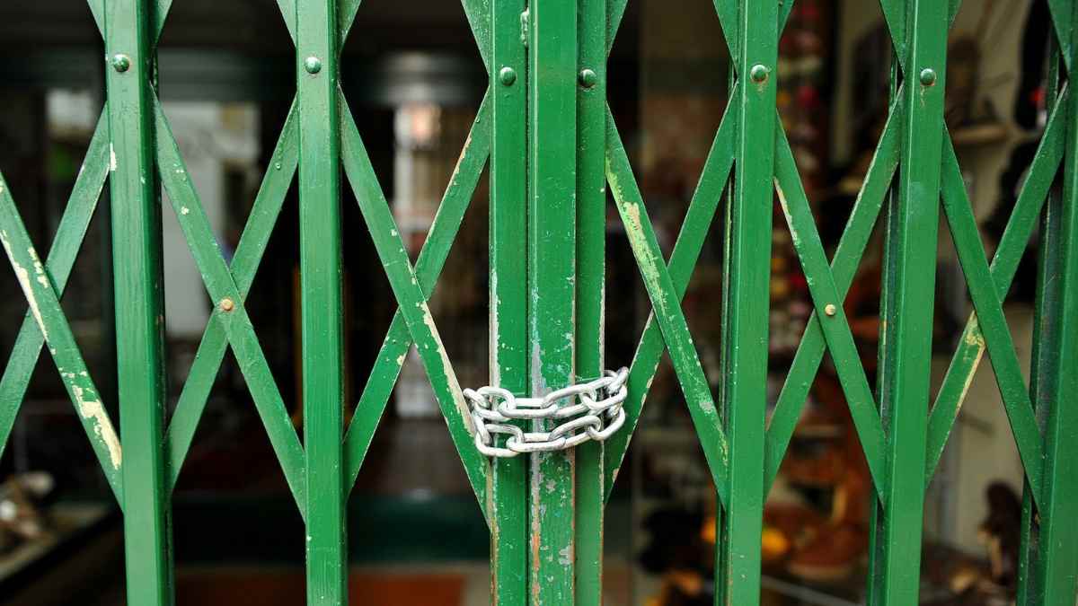 empresa cerrada con persiana metálica bajada y cadena en la puerta