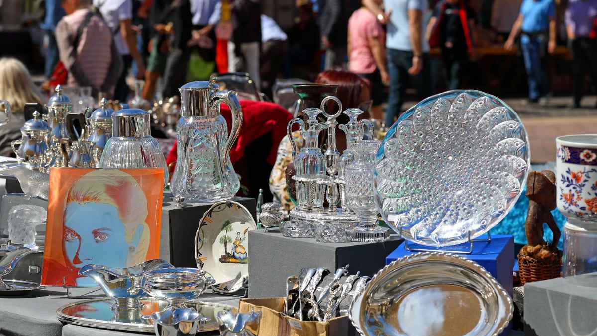 Mercadillo de antigüedades Déballage en La Moraleja con vajillas, cristalería y objetos vintage expuestos en los puestos.