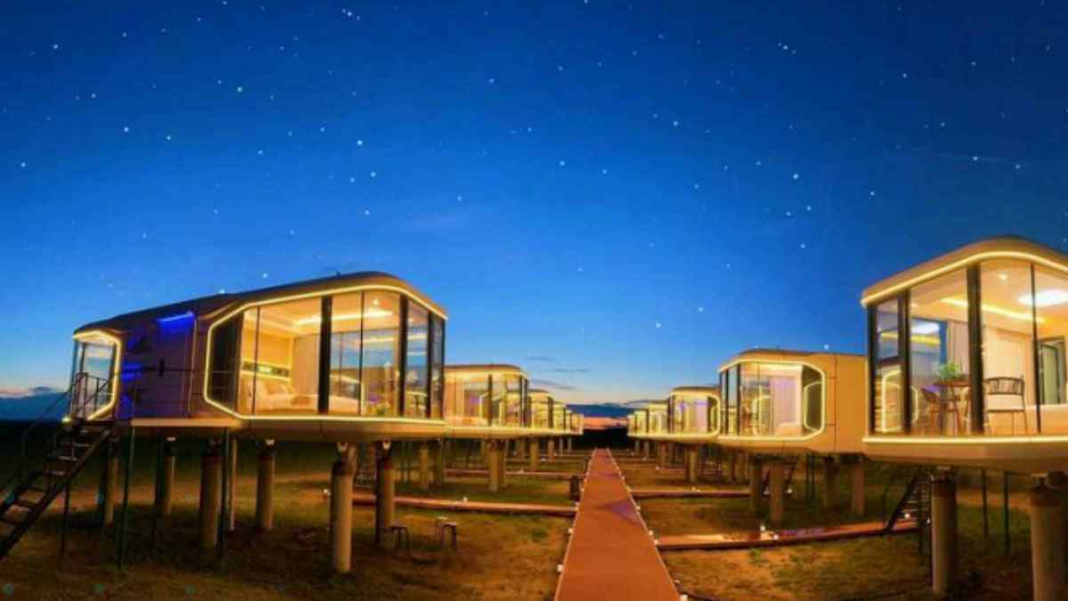 Microvivienda china modular elevada con grandes ventanales instalada en un complejo de casas cápsula inteligentes